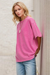 Woman wearing an oversized fuchsia Pink Basic Bae round-neck half-sleeve T-shirt styled with dark denim jeans and a long pendant necklace for a relaxed, casual look.