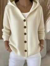Women's apricot button-up knit cardigan with hood and front pockets, long sleeve lightweight sweater styled with white pants, available in sizes Small–5XL.