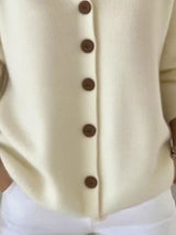 Women's apricot button-up knit cardigan with hood and front pockets, long sleeve lightweight sweater styled with white pants, available in sizes Small–5XL.