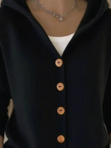 Women's black button-up knit cardigan with hood and front pockets, long sleeve lightweight sweater styled with white pants, available in sizes Small–5XL.