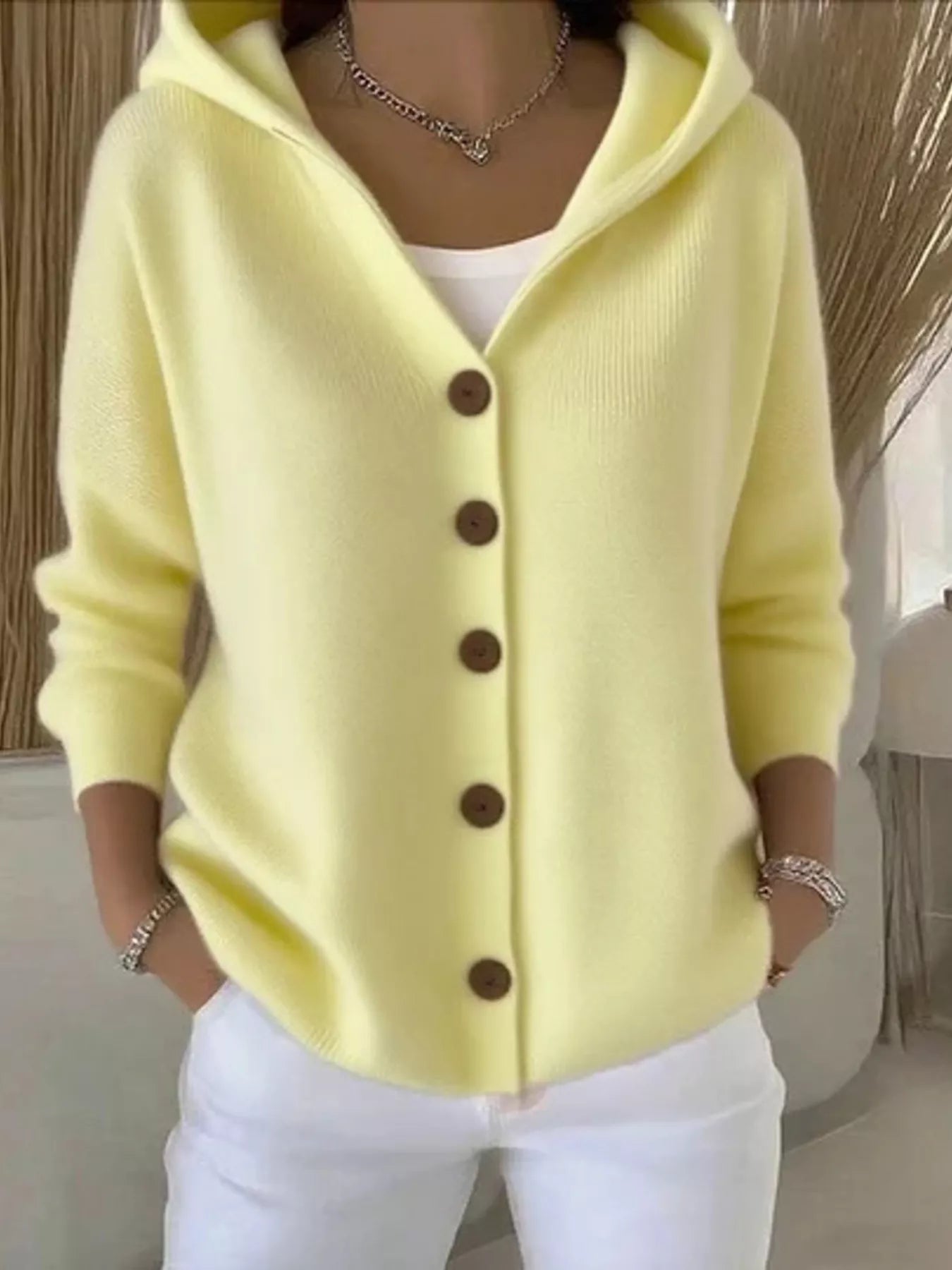 Women's light-yellow button-up knit cardigan with hood and front pockets, long sleeve lightweight sweater styled with white pants, available in sizes Small–5XL.