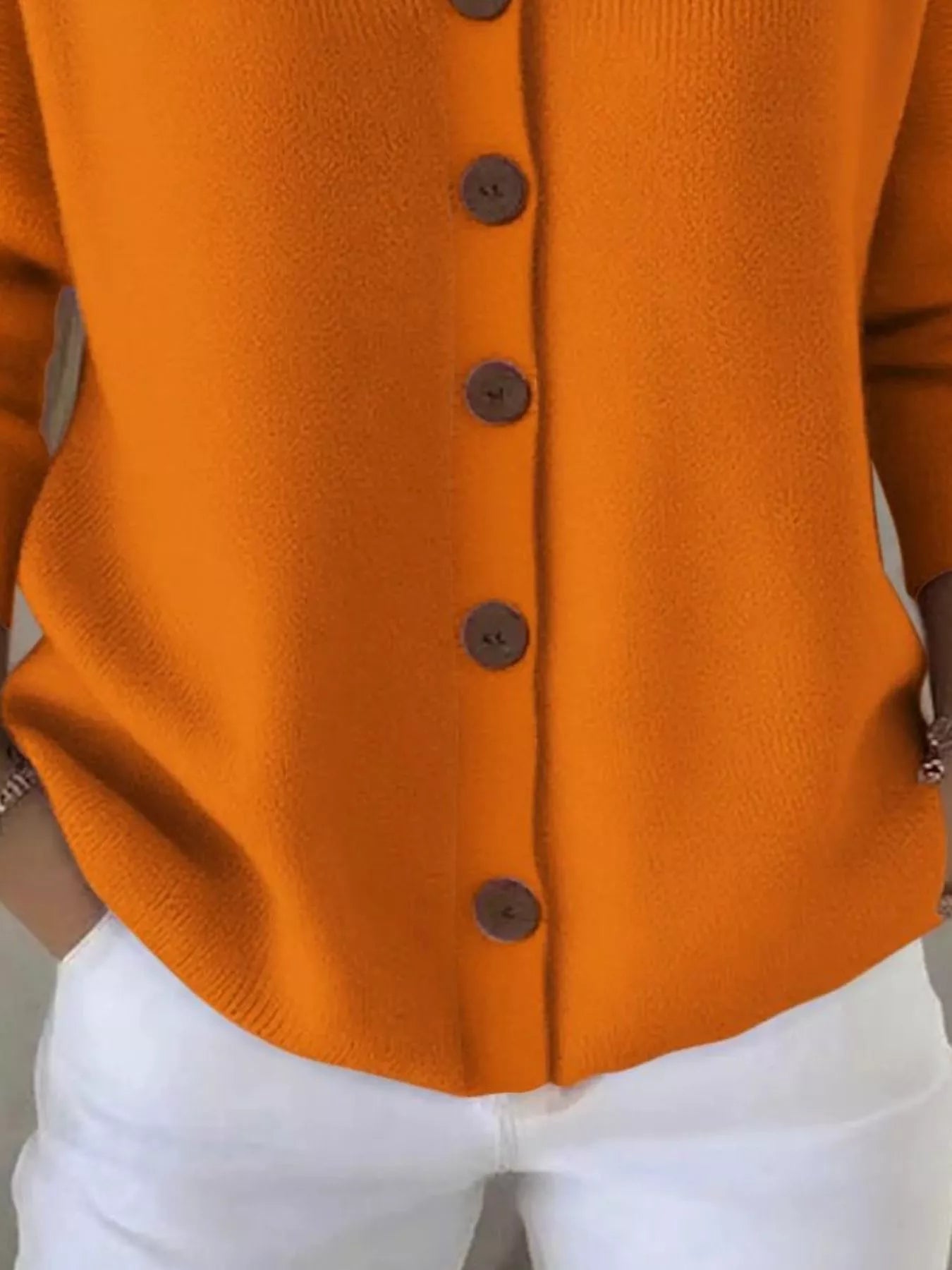 Women's orange button-up knit cardigan with hood and front pockets, long sleeve lightweight sweater styled with white pants, available in sizes Small–5XL.