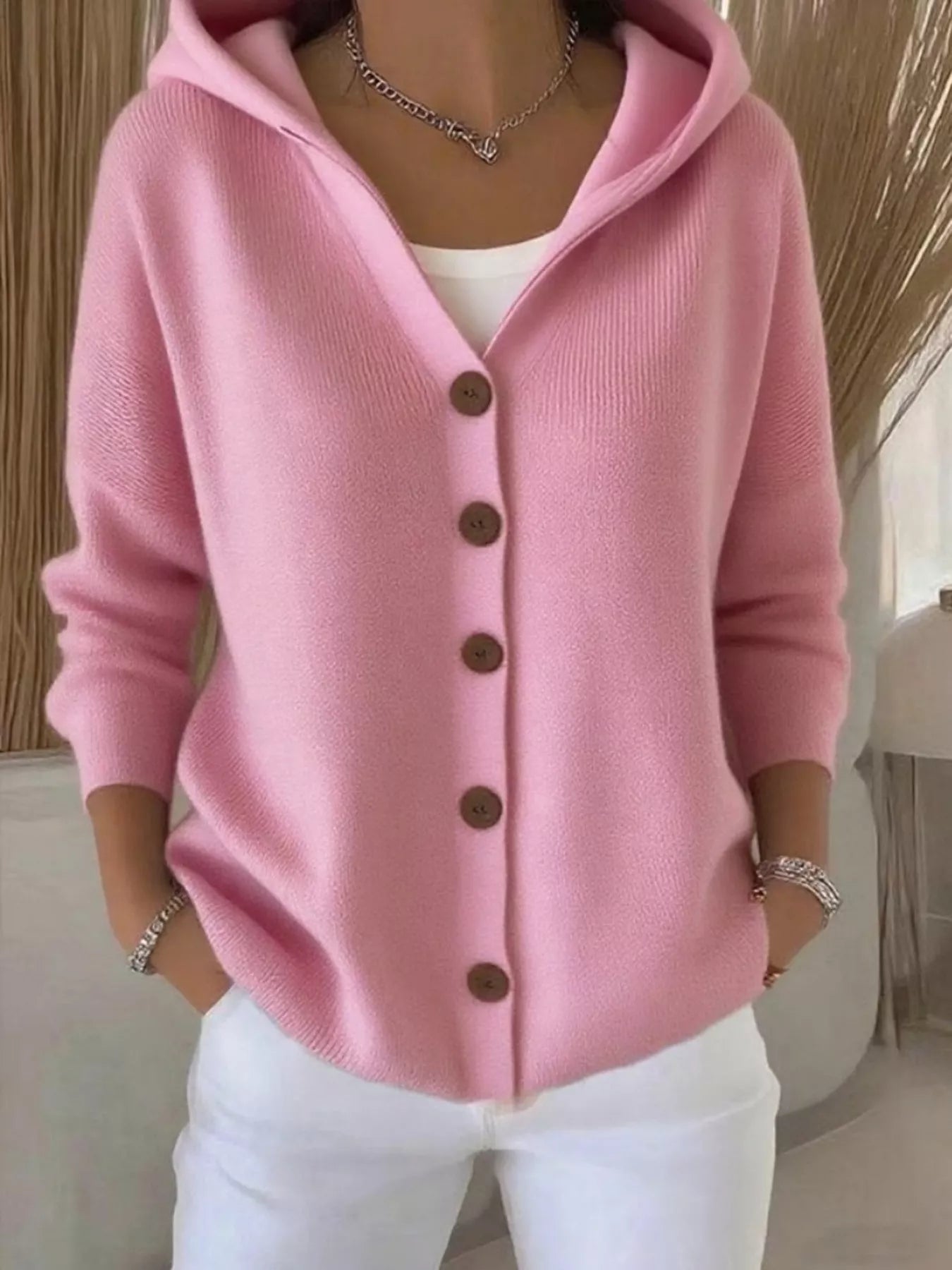 Women's pink button-up knit cardigan with hood and front pockets, long sleeve lightweight sweater styled with white pants, available in sizes Small–5XL.
