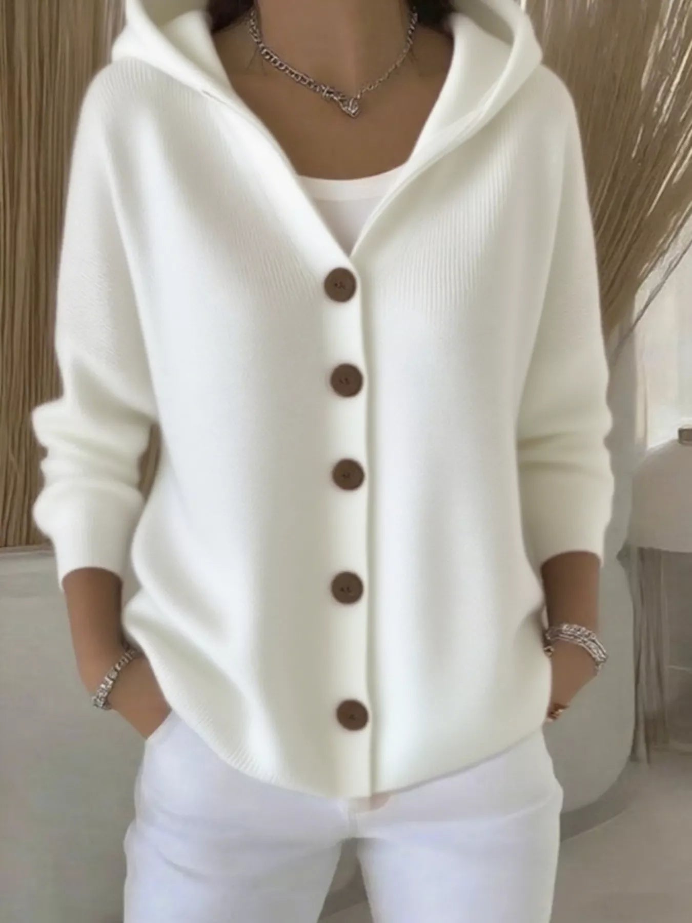 Women's white button-up knit cardigan with hood and front pockets, long sleeve lightweight sweater styled with white pants, available in sizes Small–5XL.