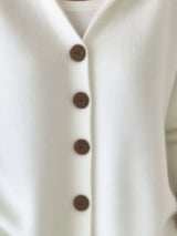 Women's white button-up knit cardigan with hood and front pockets, long sleeve lightweight sweater styled with white pants, available in sizes Small–5XL.