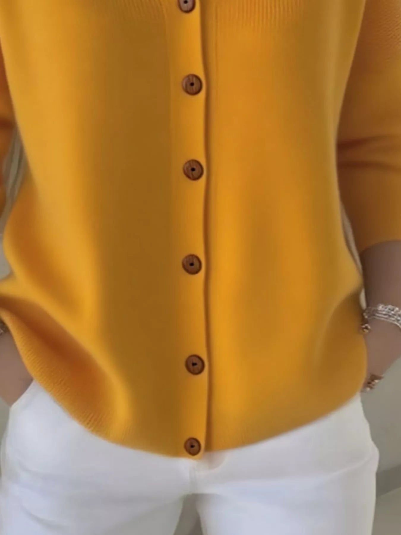 Women's yellow button-up knit cardigan with hood and front pockets, long sleeve lightweight sweater styled with white pants, available in sizes Small–5XL.