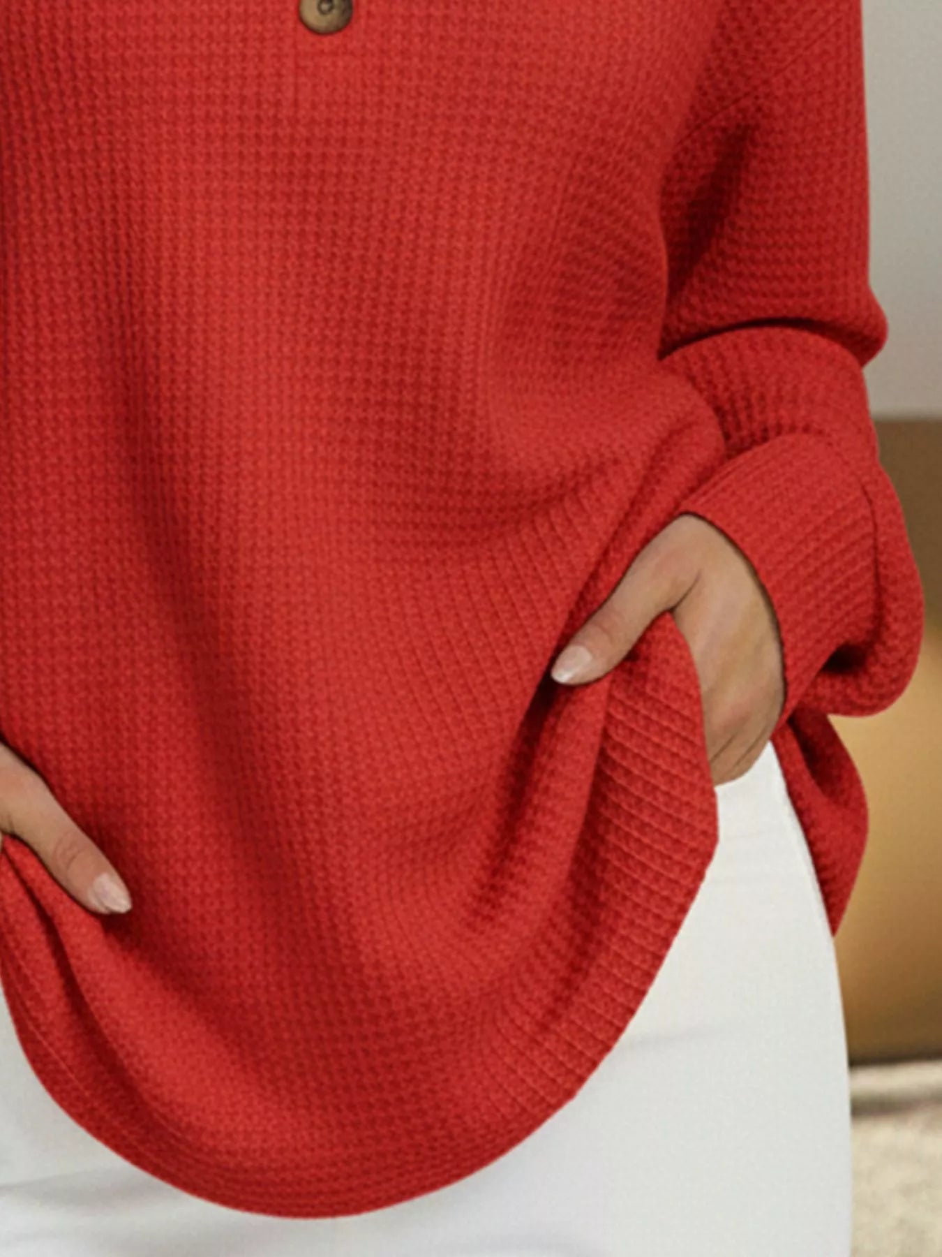 Red textured sweater worn by a person with a neutral background