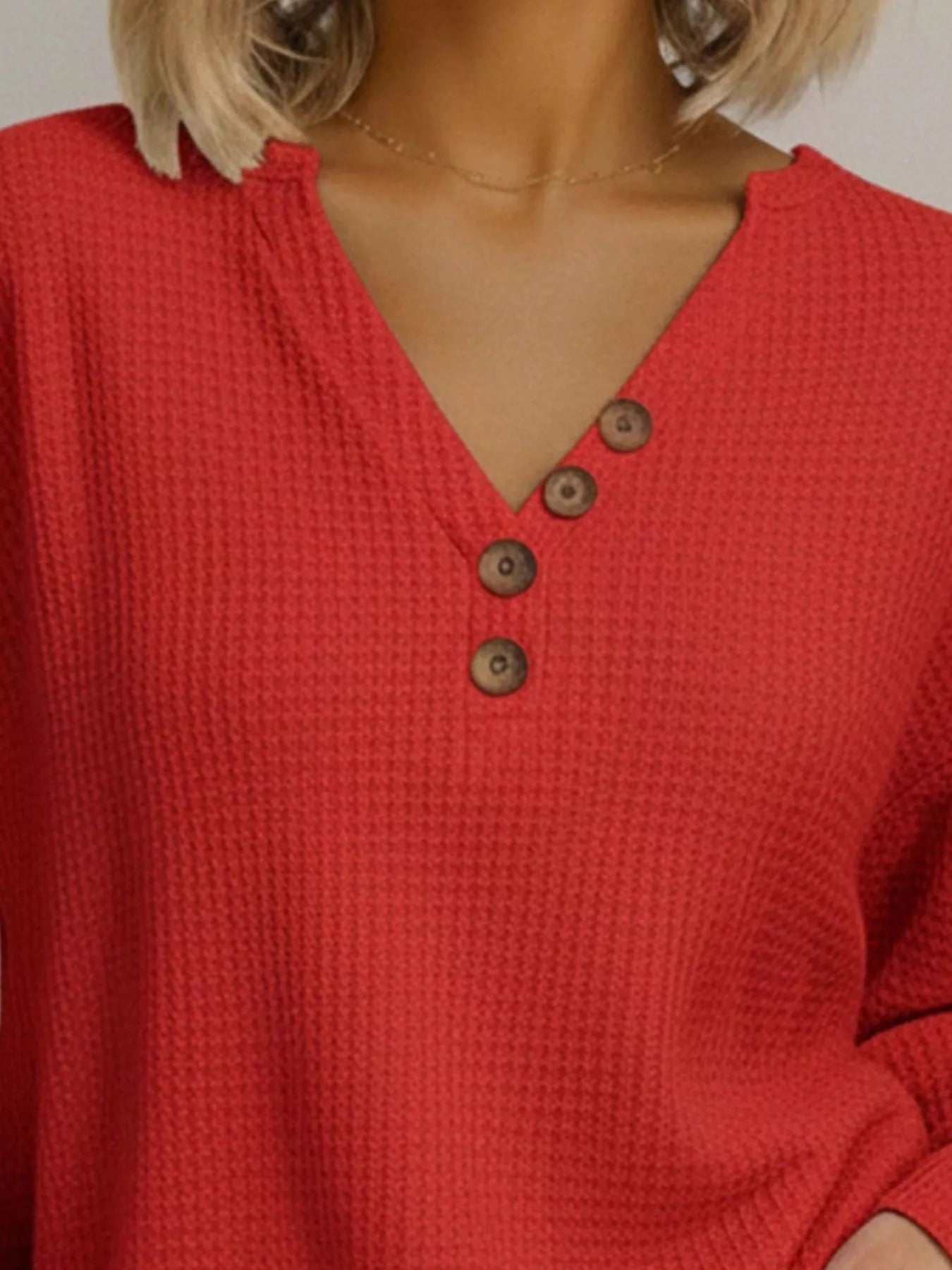 Red textured shirt with brown buttons worn by a person
