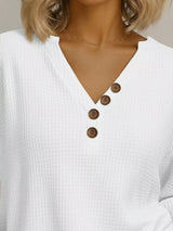 White textured shirt with brown buttons worn by a person