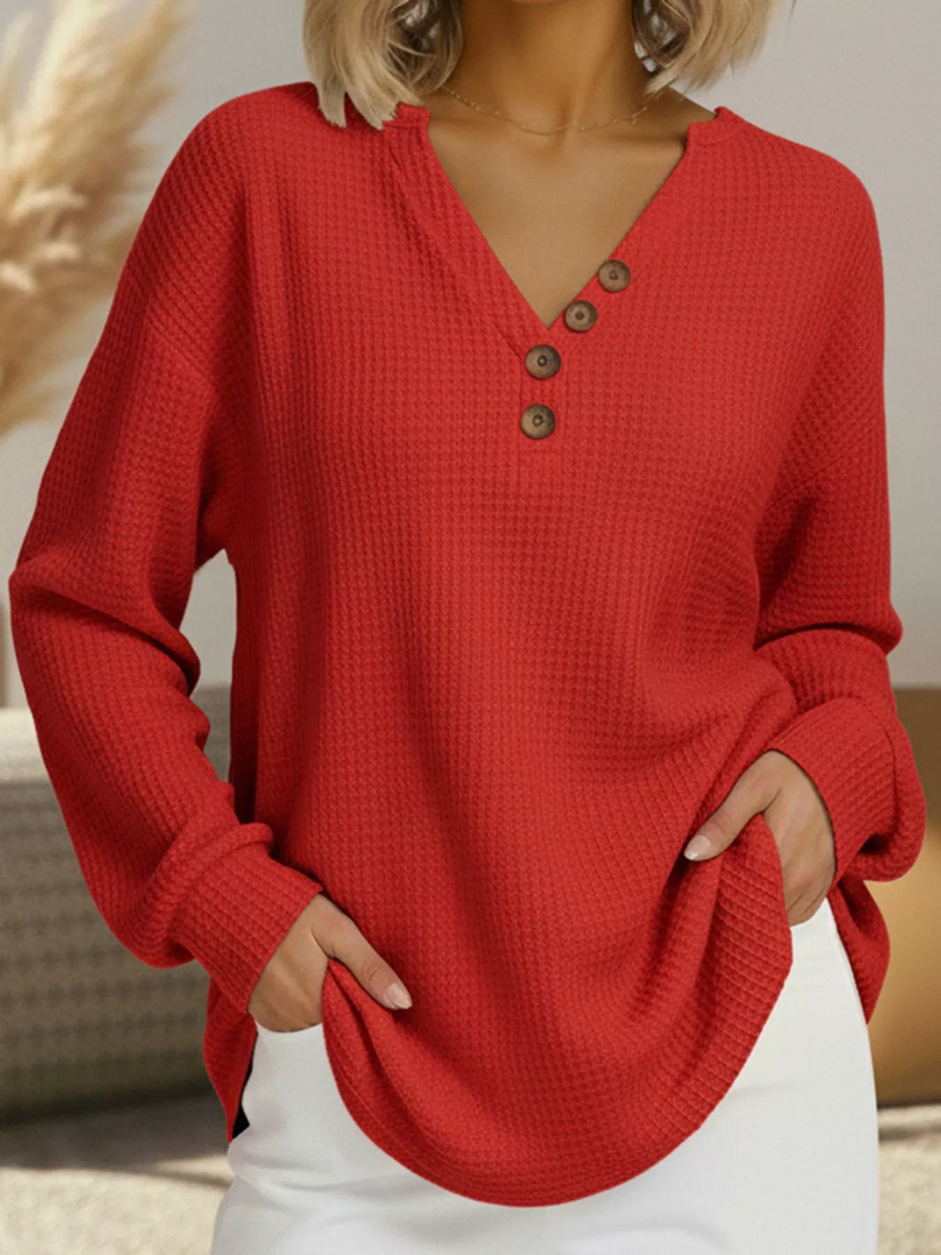 Red textured long-sleeve top worn by a person indoors.