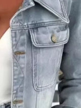 Woman wearing a light blue cropped denim jacket over a white top with light-wash jeans and a structured handbag, styled for a chic fall outfit.