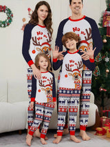 Family of four wearing matching Christmas reindeer pajamas with navy sleeves, red trim, smiling Santa-hat reindeer graphics and festive patterned pants.