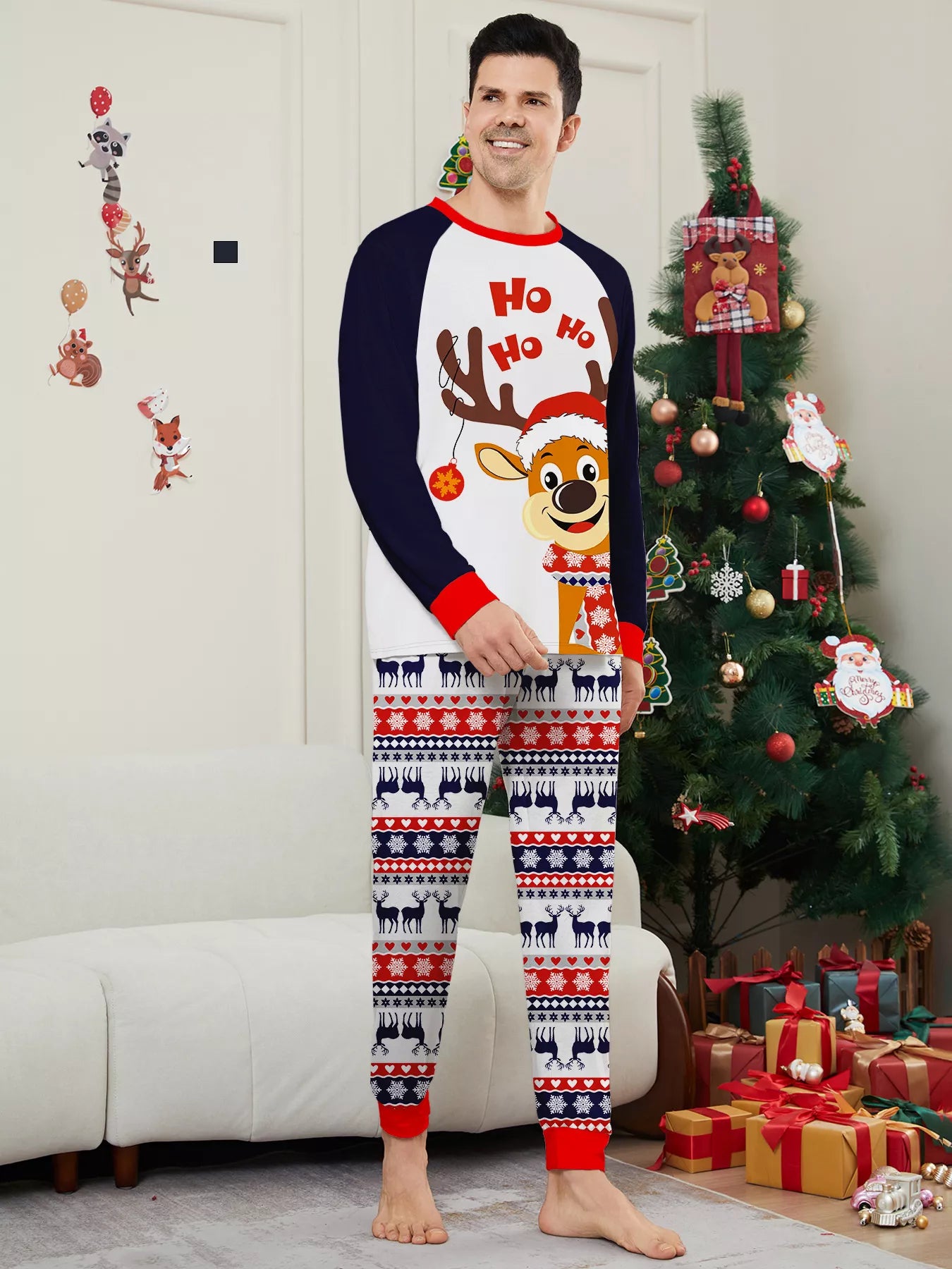 Dad wearing matching Christmas reindeer pajamas with navy sleeves, red trim, smiling Santa-hat reindeer graphics and festive patterned pants.