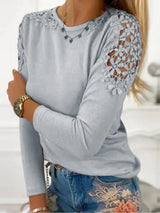 Gray long-sleeve top with lace details on sleeves and neckline, worn with blue jeans.