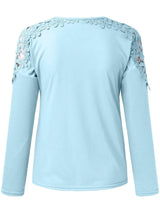 Pastel blue long-sleeve top with floral lace details on shoulders against a white background