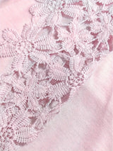 Close-up of white lace on a pink fabric background