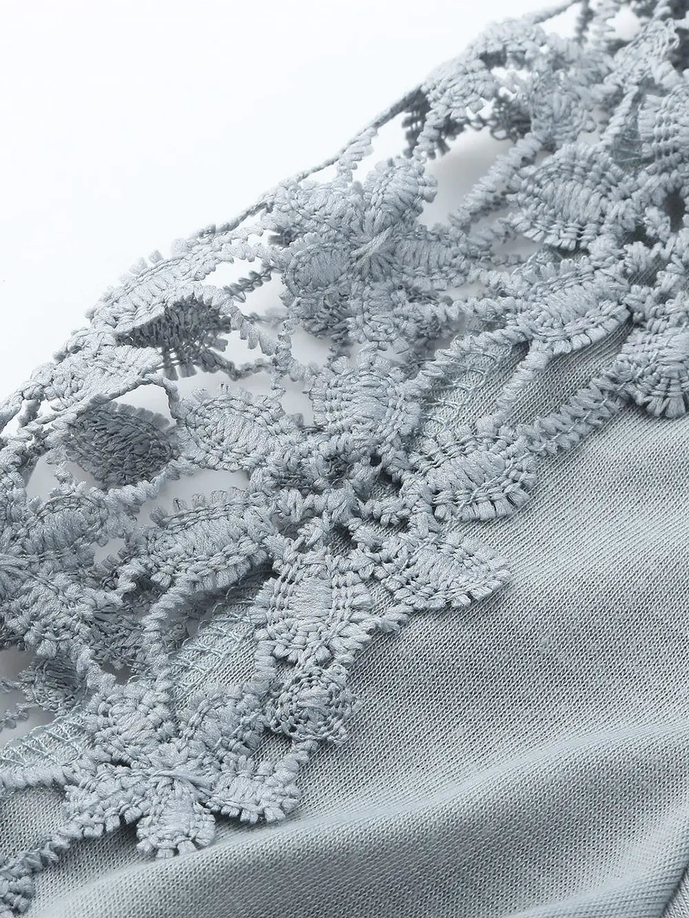 Close-up of textured fabric with lace detailing on a white background