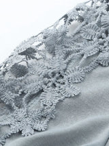 Close-up of textured fabric with lace detailing on a white background