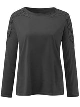Black long-sleeve top with lace details on shoulders against a white background