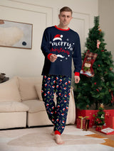 Man wearing navy blue Merry Christmas pajama sets with red trim and holiday-print pants.