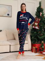 Woman wearing navy blue Merry Christmas pajama sets with red trim and holiday-print pants.