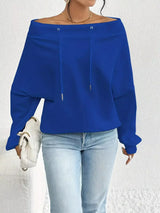 Blue off-shoulder top worn by a person on a white background