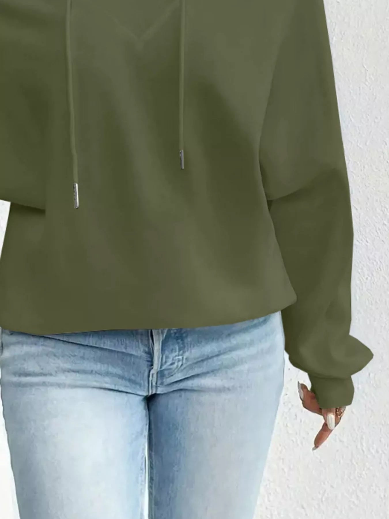 Green hoodie worn by a person on a white background