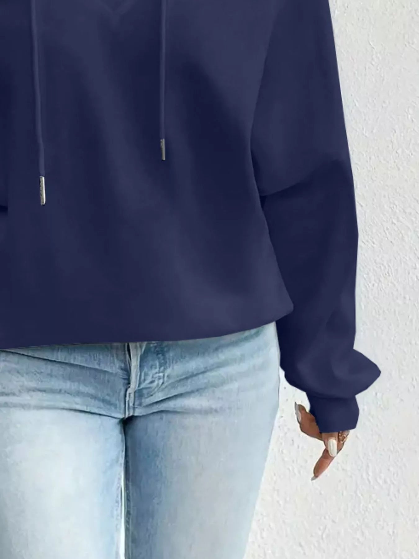 Navy blue hoodie worn by a person on a white background