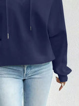 Navy blue hoodie worn by a person on a white background