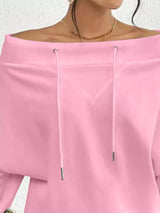 Pink off-shoulder top worn by a person on a white background