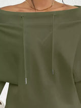 Green off-shoulder top with drawstrings on a neutral background