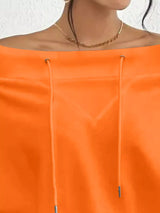 Orange red off-shoulder top worn by a person with a neutral background