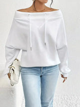 White off-shoulder blouse worn by a person on a white background