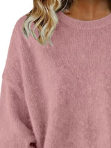Woman wearing a pink round neck dropped shoulder sweater with dark-wash jeans.