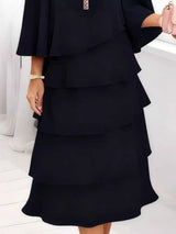 Black layered dress worn by a person on a white background