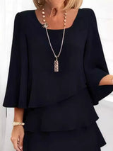 Woman wearing a black outfit with a necklace on a white background