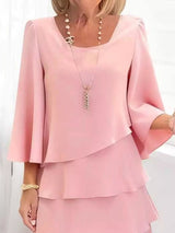 Pink dress with layered skirt and three-quarter sleeves on a white background