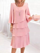 Woman wearing a pink dress with a matching clutch against a white background