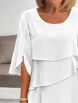 White layered dress worn by a person with a neutral background