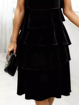 Black tiered dress worn by a person on a white background