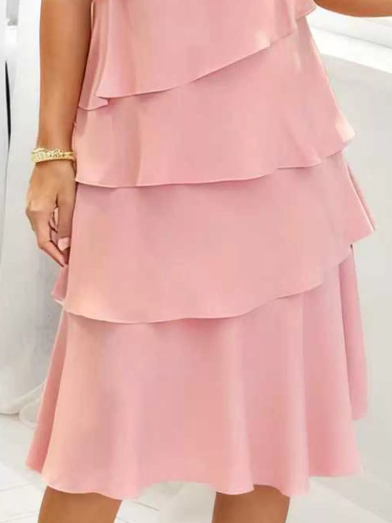 Blush pink tiered dress on a white background