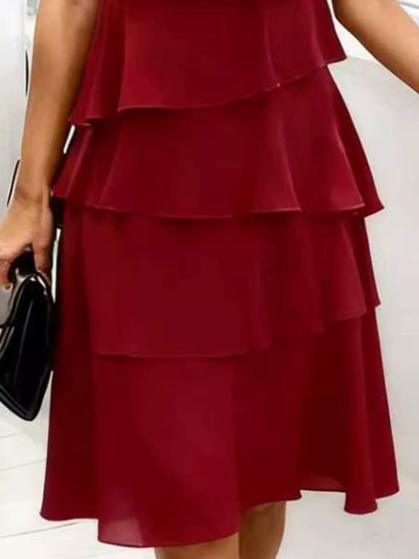 Burgundy tiered dress worn by a person on a white background