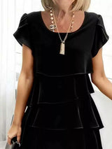 Black dress with ruffled sleeves and layered skirt worn by a person.