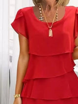 Scarlet layered dress worn by a person with a white background