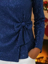 Blue glittery dress with a tie detail on a blurred background