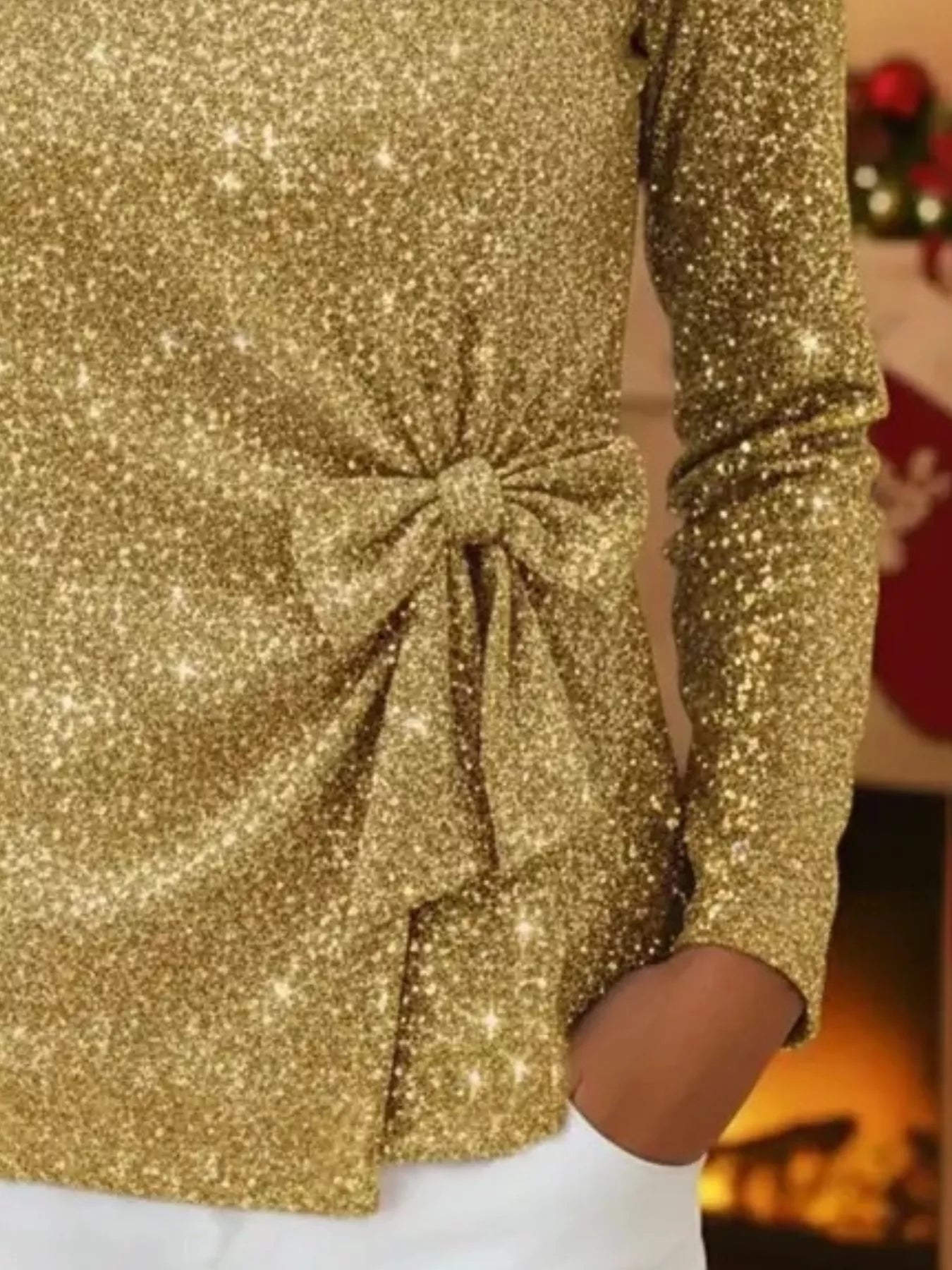 Gold glittery dress with a large bow detail, blurred background