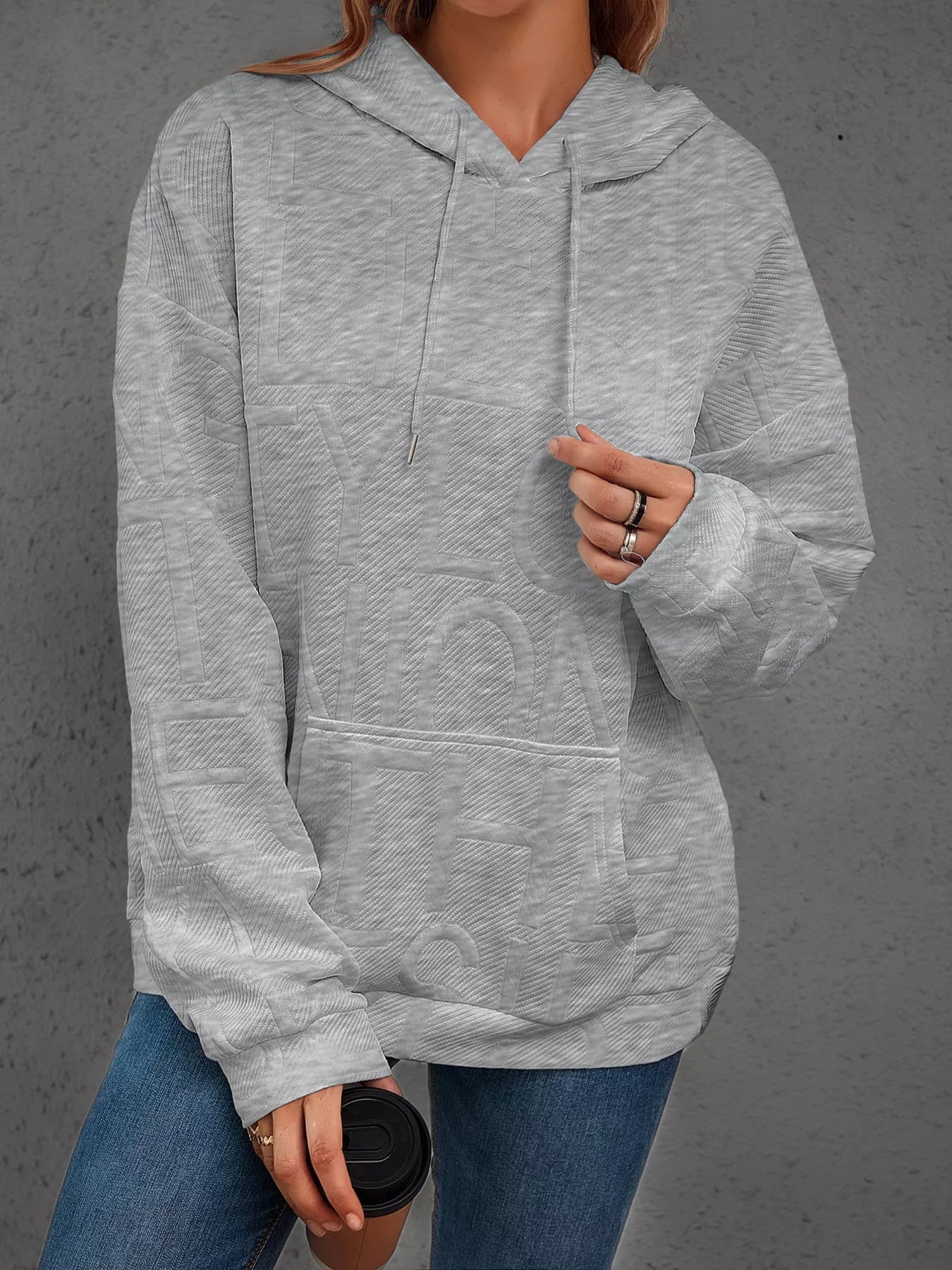 Person wearing a gray hoodie with a blurred background