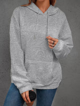 Person wearing a gray hoodie with a blurred background