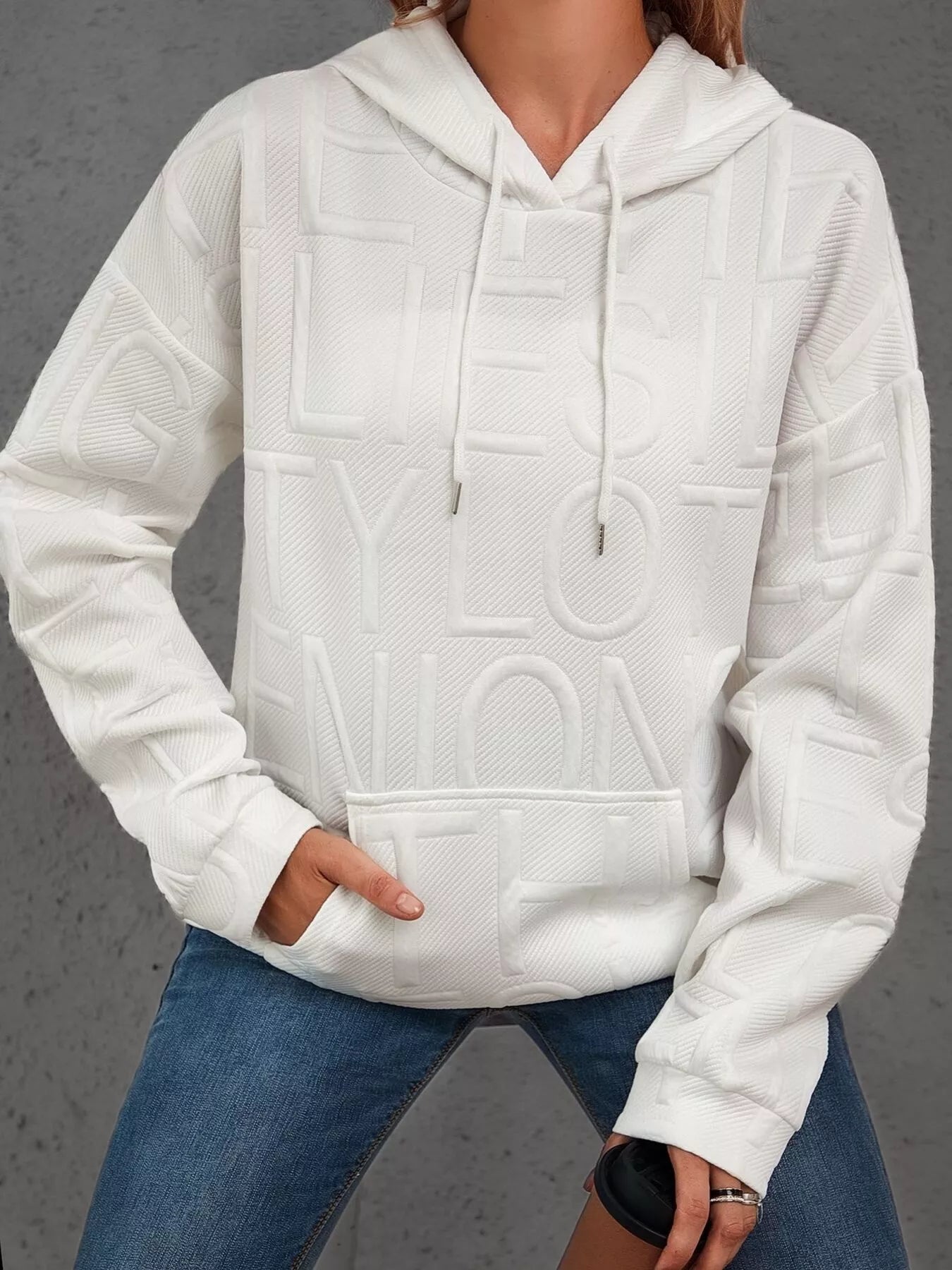 White textured hoodie worn by a person on a gray background