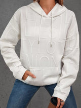 White textured hoodie worn by a person on a gray background